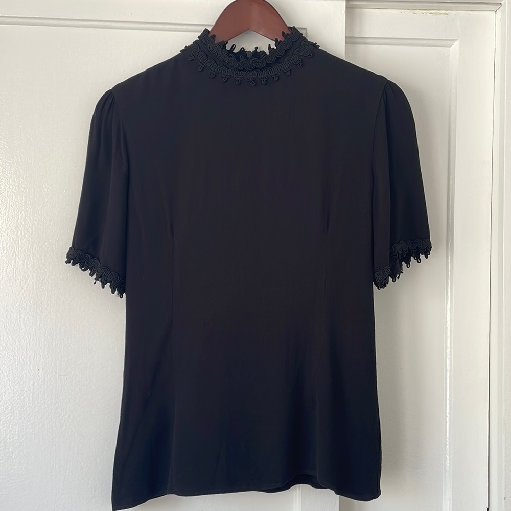 Black high neck top with neck and sleeve details
